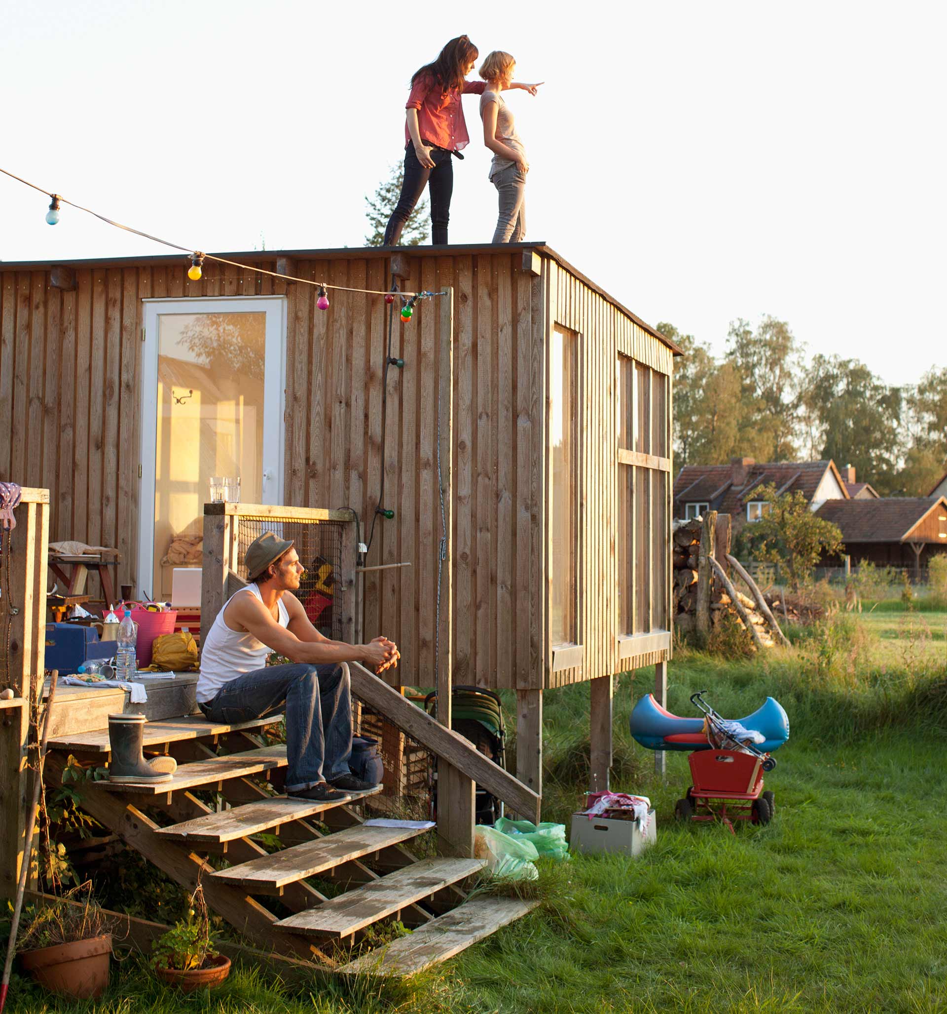 Junge Menschen am selbst gebauten Gartenhaus