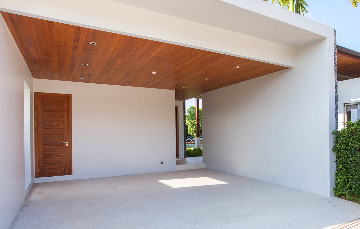 Carport an einem weißen Haus mit Holzelementen