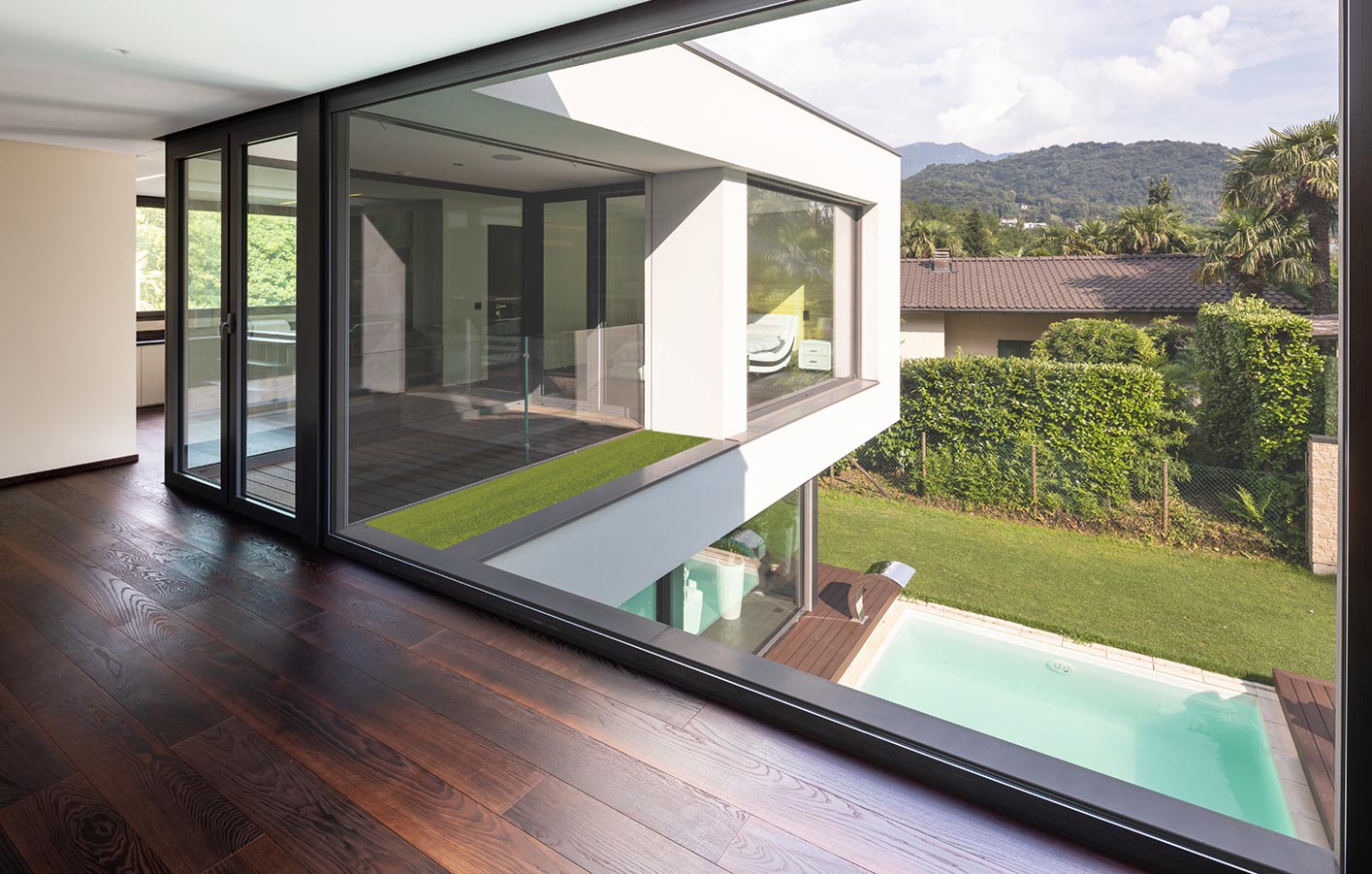 Parkettboden aus Eiche in einem Zimmer mit Ausblick in einen Garten mit Pool