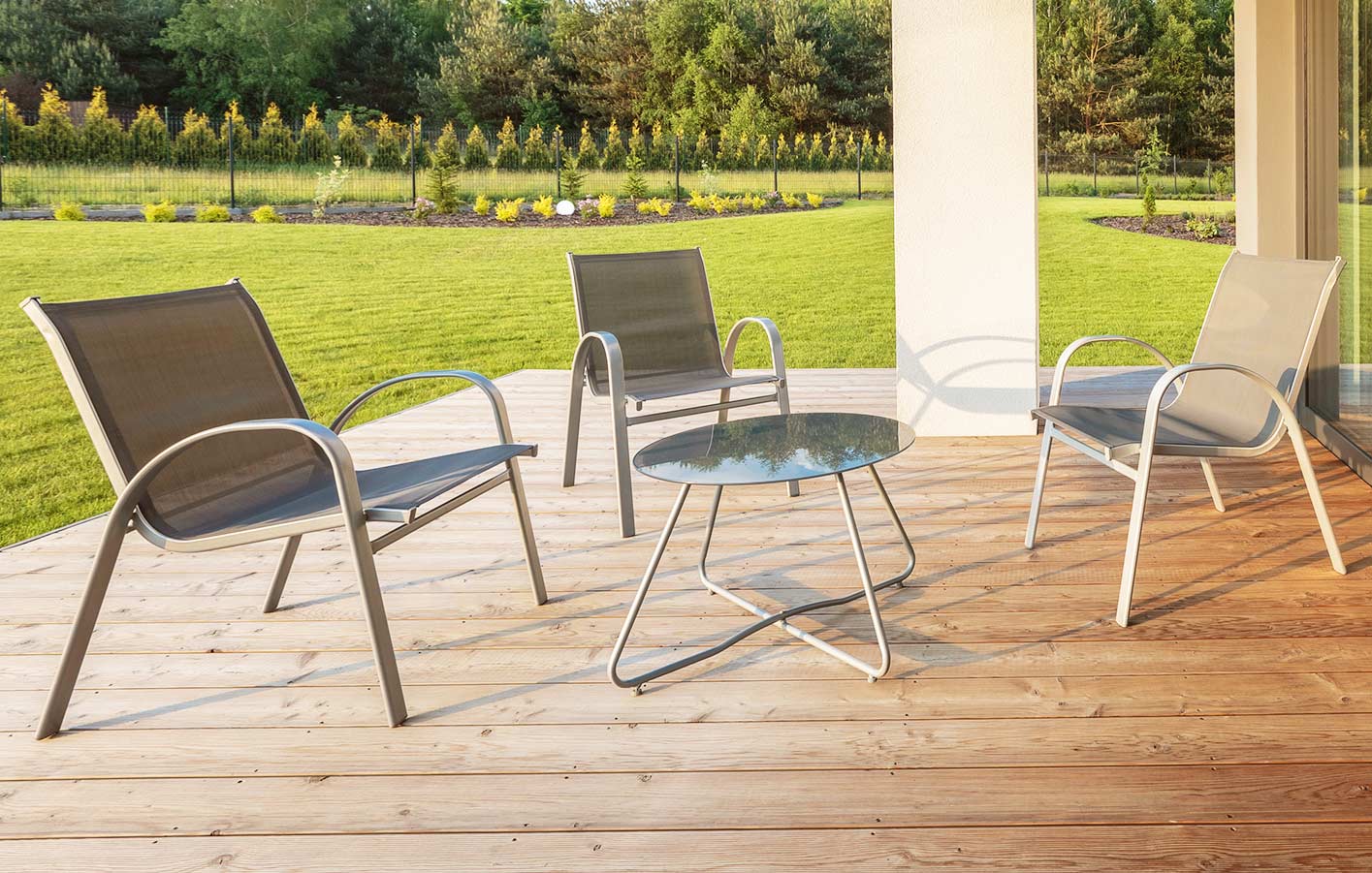 moderne Terrasse mit Gartenmöbeln mit Blick auf einen grünen Garten