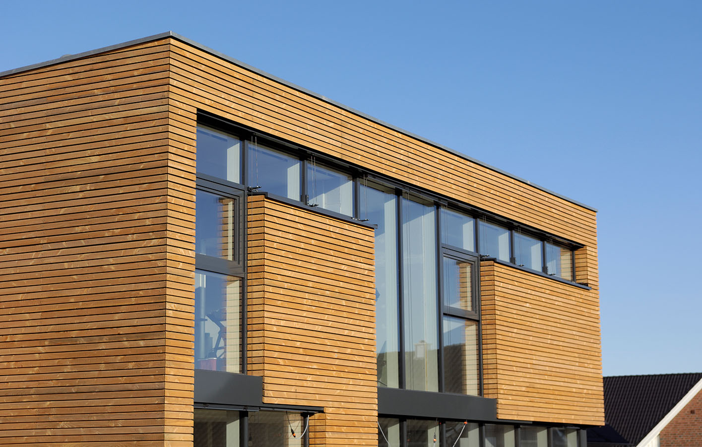 Holzfassade an einem Haus mit großer Fensterfläche